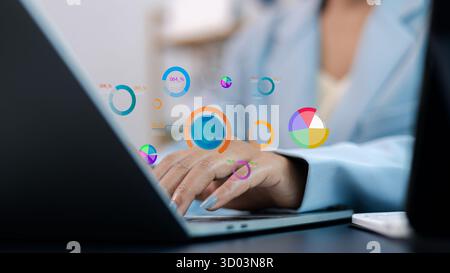 Close-up of businesswoman using laptop with colorful data charts and analytics icons. Modern digital marketing and business dashboard concept showing Stock Photo