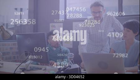 Collaborating colleagues adjusting data on laptop and PC in office, with floating numeric overlays Stock Photo
