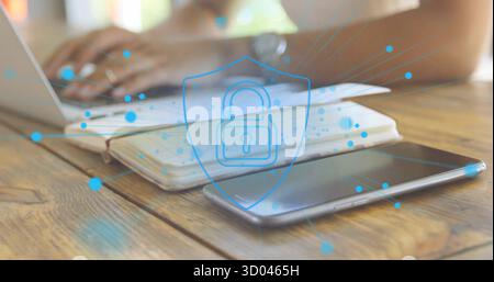Working woman typing on laptop at office desk with notebook and tablet under security shield Stock Photo