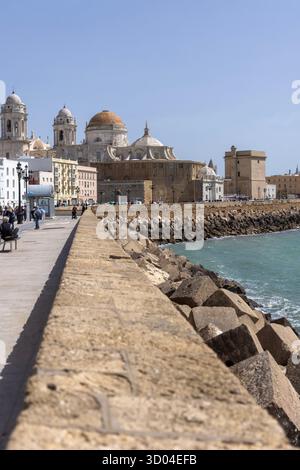 Cadiz, Spain, Andalusia - March 31, 2025: Picturesque seaside Gale Promenade (Paseo del vendaval) along Atlantic, view of 18th century Cadiz Cathedral Stock Photo