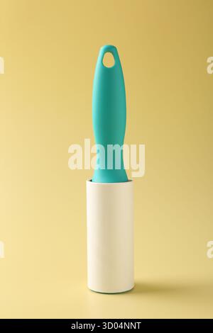 One sticky lint roller on yellow background Stock Photo