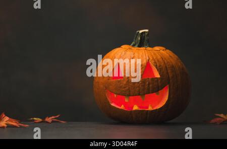 Creepy Halloween Pumpkin with Glowing Red Eyes and Smoke on black background Stock Photo