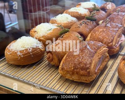 Assorted croissants and pastries with cheese and ham. Savory flavor, texture, and artisanal baking in modern cafe display. Stock Photo