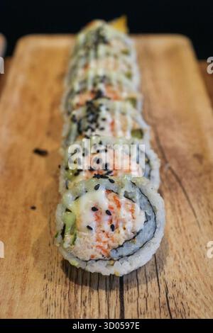Asian fusion sushi rolls on a wooden board. Top-down view. Healthy meal, Kimbap, restaurant menu, and modern food photography. Stock Photo