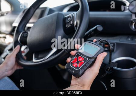 Woman using OBD2 diagnostic scanner.  Stock Photo