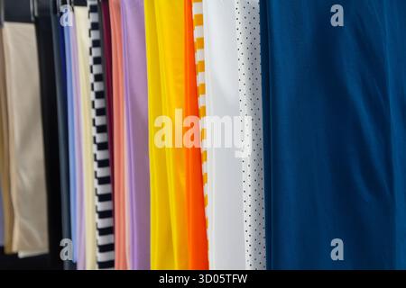Colorful textile fabric rolls in a vertical arrangement on display. Industry Stock Photo