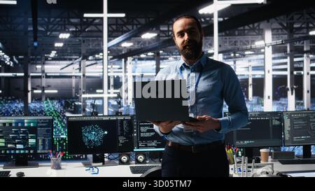 Data center manager presents AI technology to shareholders, demonstrating predictive maintenance capabilities. Man briefing investors on server hub artificial intelligence infrastructure, camera A Stock Photo