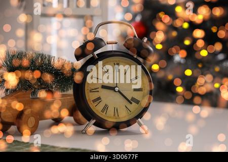 Alarm clock with Christmas tree and toy car on table in room Stock Photo