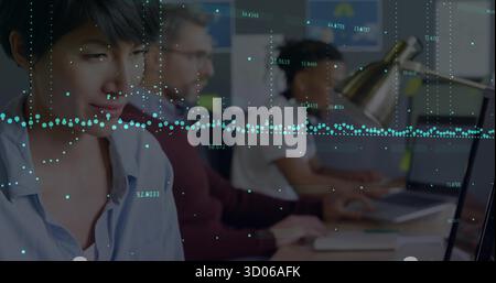 Working Asian woman typing on laptop at office desk with metallic lamp, data graphs, copy space Stock Photo