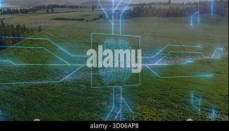 Displaying neon-blue digital circuit overlay tracing farmland aerial view, showing fingerprint node Stock Photo