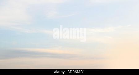 Serene view of softly lit morning or evening sky creating abstract natural background. Colors delicate blend pale pastel shades primarily featuring li Stock Photo