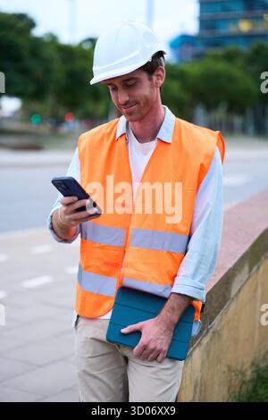 Engineer managing construction site work with digital devices Stock Photo