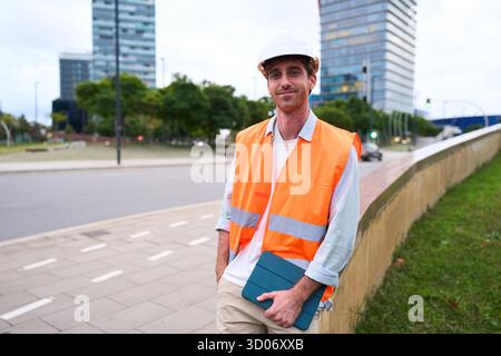 Engineer worker wearing safety vest holding tablet smiling Stock Photo