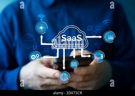 A businessman using a smartphone with SaaS cloud computing concept, representing software as a service, digital transformation, online business techno Stock Photo
