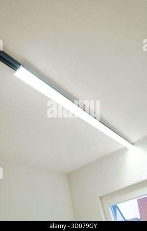 Slim LED light strip on white ceiling next to a window, clear and modern, house renovation, energy renovation, Metzingen, Germany Stock Photo