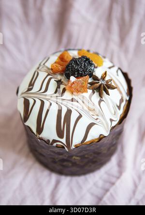 A delicious Easter cake, adorned with a marbled chocolate and white icing, is decorated with dried fruits and spices. It's a festive treat perfect for Stock Photo