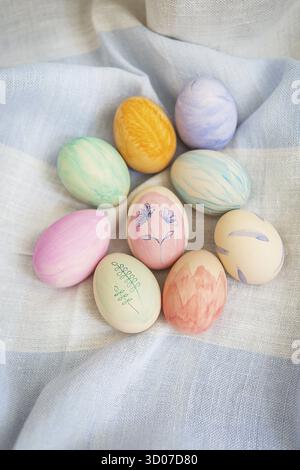 Painted bright and multi-colored Easter eggs on the background of a linen tablecloth, eggs painted with watercolors Stock Photo