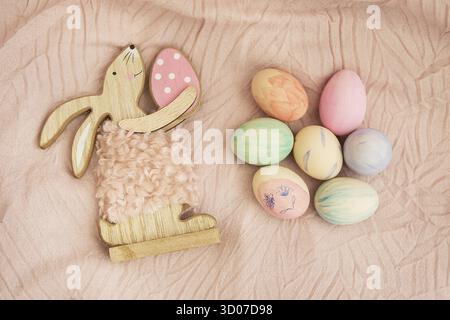 Beautiful Easter eggs, decorated with watercolors, which lie on a delicate pink fabric together with the Easter bunny. Easter and holidays concept Stock Photo