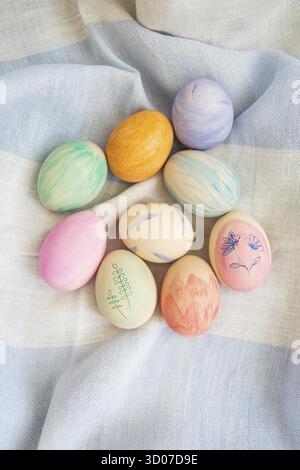Painted bright and multi-colored Easter eggs on the background of a linen tablecloth, eggs painted with watercolors Stock Photo