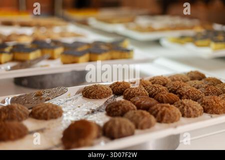 A selection of sweet treats is beautifully arranged on trays for guests to enjoy at a celebration. Different pastries and candies are presented, showc Stock Photo