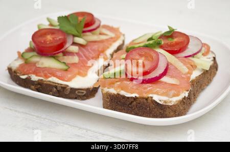Two healthy open sandwiches in plate on wooden background Stock Photo