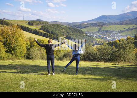 Summer landscape in the mountains and a beautiful blue sky with clouds-a loving couple sitting on the background Stock Photo