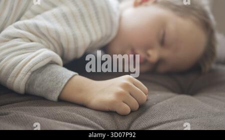 Close up shot of cute sleeping boy, focus on hand Stock Photo