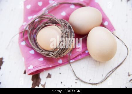Three eggs on the table on a rose napkin Stock Photo