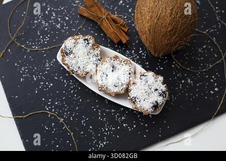 Coconut muffins with chocolate on a black background and whole coconut Stock Photo