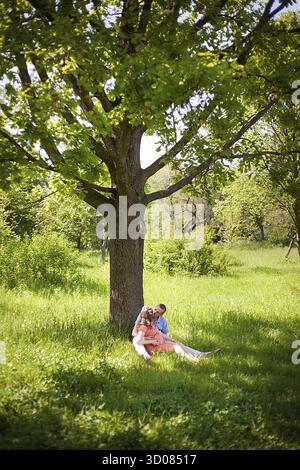 Couple of lovers resting under big oak Stock Photo