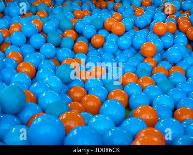 Close-up of a large collection of blue-purple and brown plastic kids' balls as a playful background Stock Photo