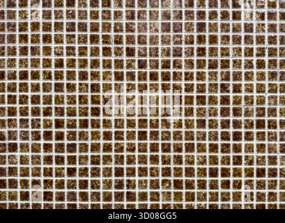 Mosaic tile pattern forms geometric grid. Small square ceramic brown tiles create textured decorative surface with symmetrical abstract design, classi Stock Photo