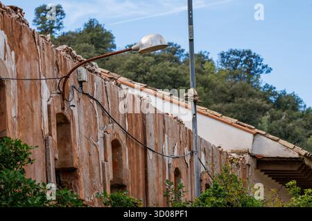A solitary streetlight projects from the ruined wall of an old building in Font Roja, Alcoy, Spain Stock Photo