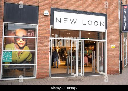 Store frontage of a New Look shop in Kidderminster, UK, displaying large logo sign above open entrance doors. Stock Photo