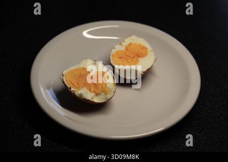 view from above on a rare half boiled chicken egg with double yolk on a white plate. Photo by Willy Matheisl Stock Photo