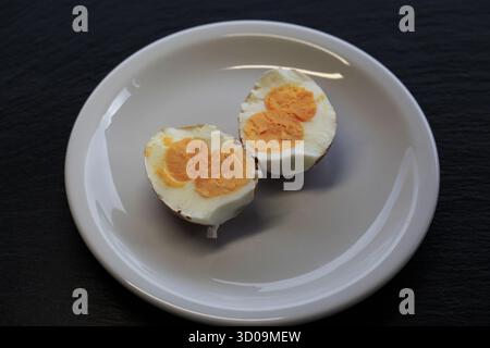 view from above on a rare half boiled chicken egg with double yolk on a white plate. Photo by Willy Matheisl Stock Photo
