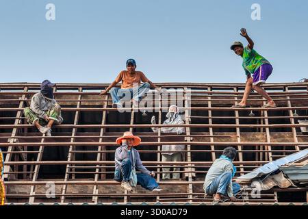 Bangkok, Thailand - November 6, 2007: Thai workers on a building roof, roofer contractors team on wooden frame of a rooftop. Stock Photo