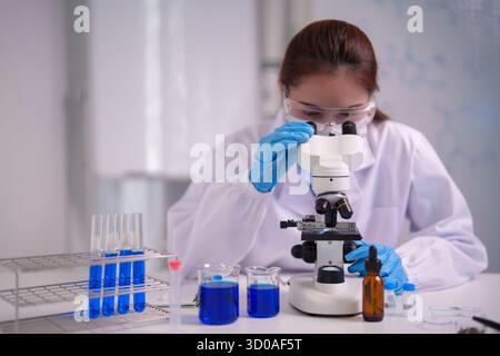Focused Asian adult woman scientist performs precise scientific research in a clean laboratory Her work contributes to medical breakthroughs Stock Photo