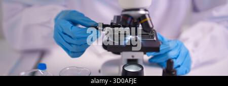 Professional scientist performs precise sample examination using advanced laboratory microscope. Focused research drives scientific discovery innovati Stock Photo