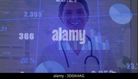 Standing female doctor displaying bar and pie chart overlays in medical office with stethoscope Stock Photo