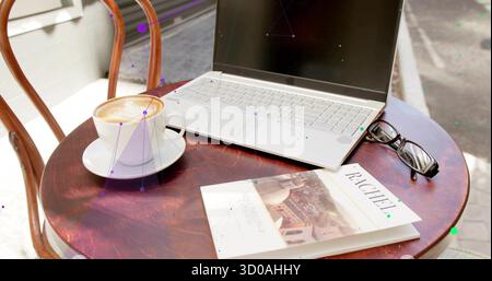 Sitting silver laptop on table at street cafe, with cappuccino, travel guide RACHEL, eyeglasses Stock Photo