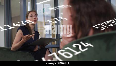 Gesturing businesswoman holding gray folder discussing data analytics in office, with green chairs Stock Photo