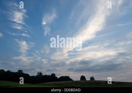 A clear blue sky with a few clouds. The sky is very open and the clouds are scattered Stock Photo