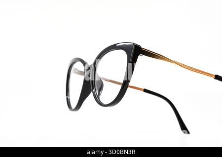 Pair of women's glasses with a black frame in a cat eye shape isolated on a plain white background. Copy space. Stock Photo
