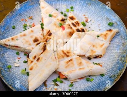 Sliced ham and cheese wraps. Fried patties or mini pies made from thin armenian lavash served with tomato sauce on a white plate with lettuce leaves. High quality photo Stock Photo