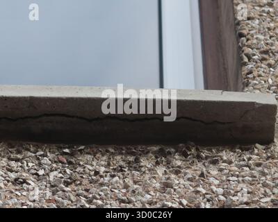House maintenance: a large crack is visible in the windowsill beneath an upstairs window indicating the concrete has failed & replacement is required. Stock Photo