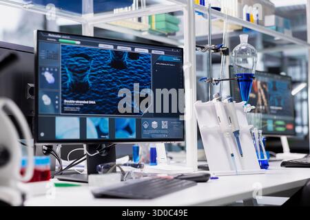 Computer monitor in biotechnology laboratory showing 3D molecular model visualization used for research. High tech bioengineering software on PC in medical lab displaying DNA data Stock Photo