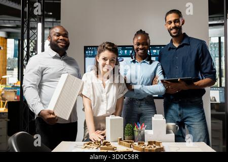 Portrait of multiethnic real estate developers planning new residential construction project to help with urban development and infrastructure growth. Smiling team of contractors briefing. Stock Photo