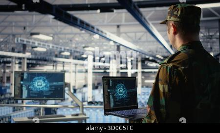 Army programmer in high tech server hub uses AI application on laptop to review reconnaissance information. Data center IT expert wearing military uniform uses AI on notebook to plan mission, camera A Stock Photo