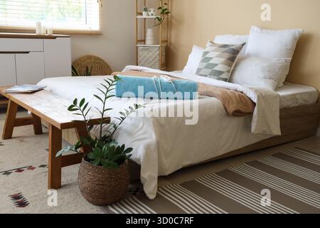 Interior of light room with electric heating pad on bed and bench Stock Photo